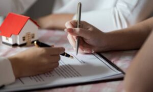 Alta land title survey closing signing - ALTA SURVEY Orlando Homebuyer and title officer reviewing an alta land title survey and signing property documents during a real estate closing