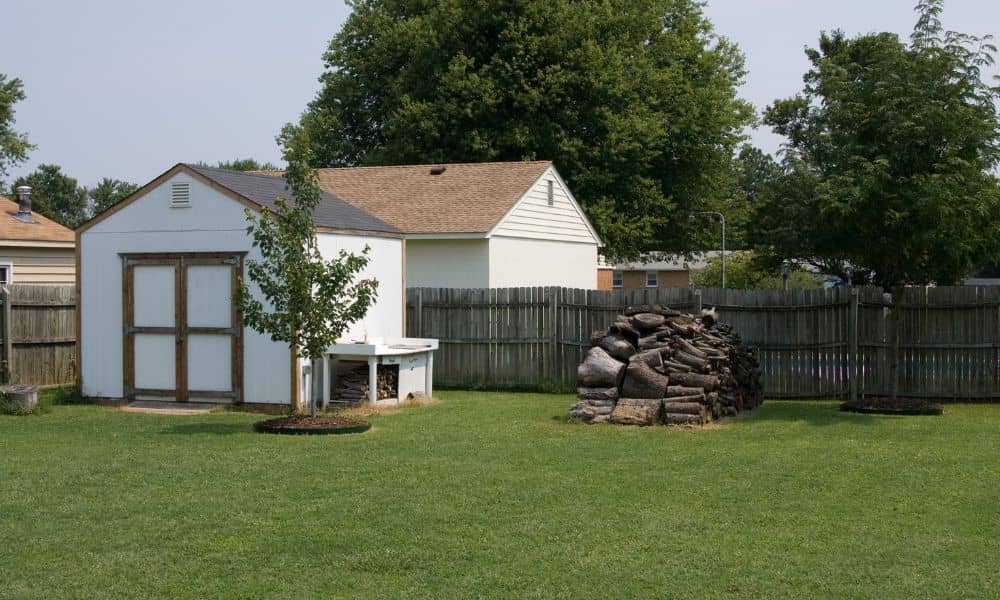 Residential backyard shed placed near a fence, highlighting a potential boundary issue addressed by a metes and bounds survey