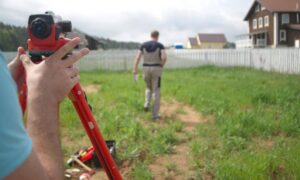 A land survey company measuring a backyard before planning an ADU