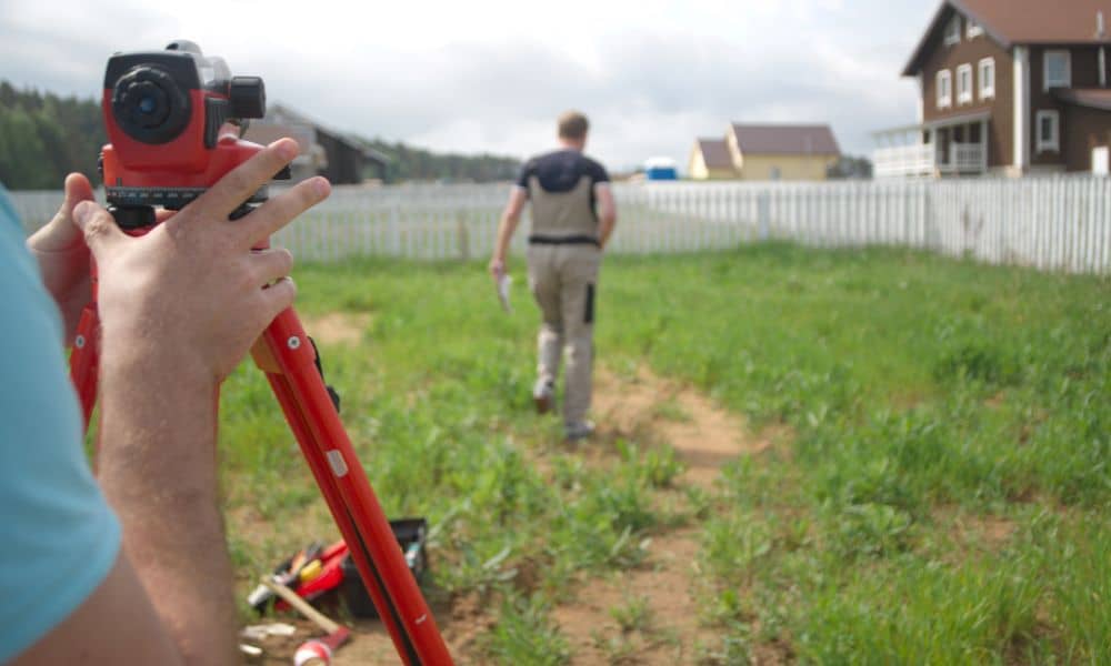 A land survey company measuring a backyard before planning an ADU